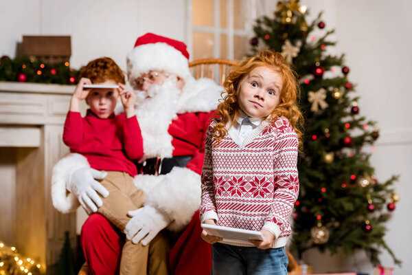 santa claus and children with digital devices