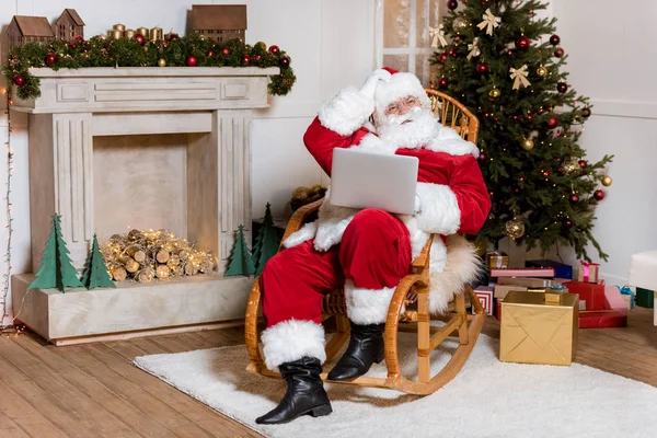 Jultomte med laptop hemma — Stockfoto