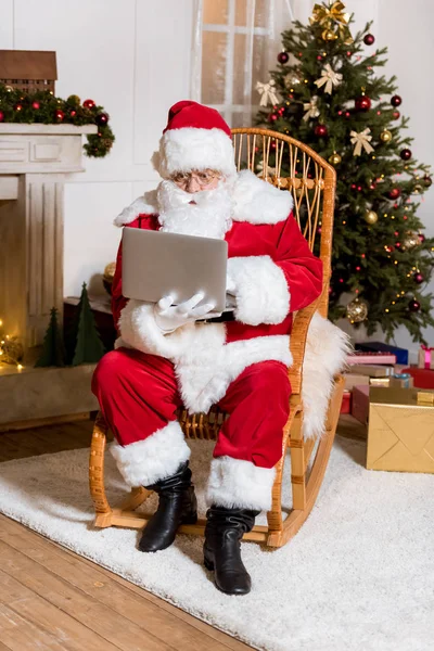 Santa claus tapant sur ordinateur portable — Photo