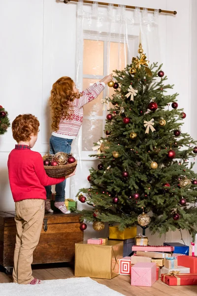 Syskon som dekorera julgran — Stockfoto