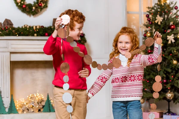 Счастливые дети с праздничными гирляндами — стоковое фото