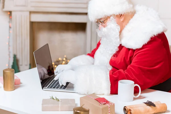 Santa claus att skriva på laptop — Stockfoto