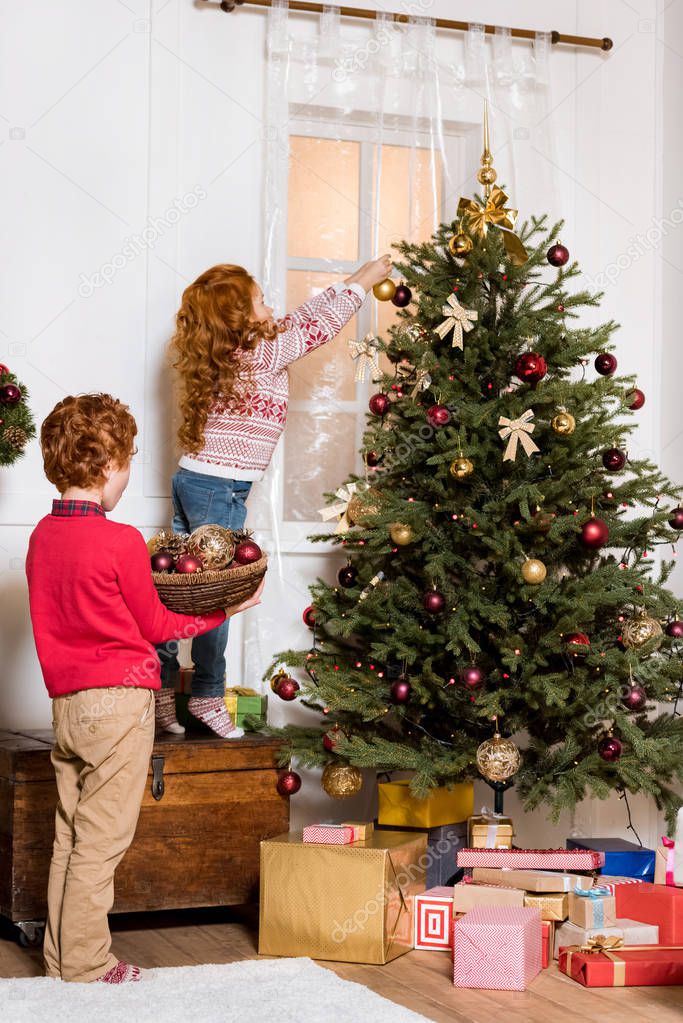 siblings decorating christmas tree
