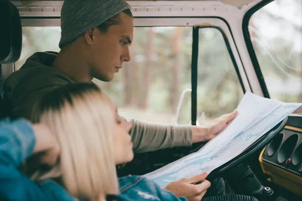 Couple of travelers with map in minivan — Stock Photo, Image