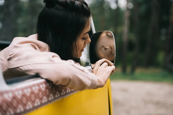 Девушка рисует знак сердца на зеркале — стоковое фото