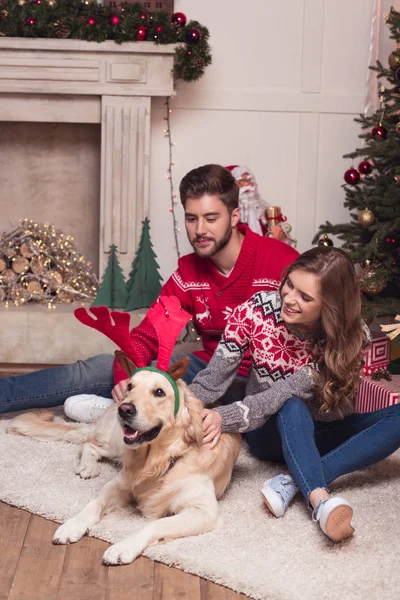 Par med hund på christmastime — Stockfoto