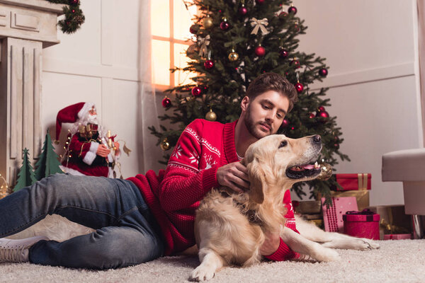 man playing with dog at christmastime