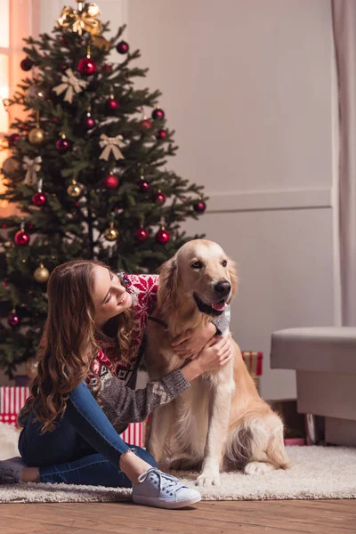 Ung kvinna och hund på christmastime — Stockfoto