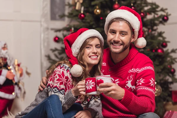 Paar mit Tassen zur Weihnachtszeit — Stockfoto