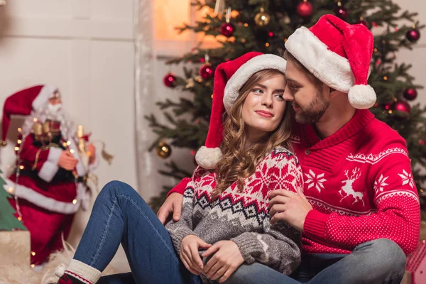 Glückliches Paar in Weihnachtsmützen — Stockfoto