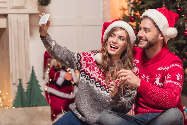 Para w santa kapelusze biorąc selfie — Zdjęcie stockowe