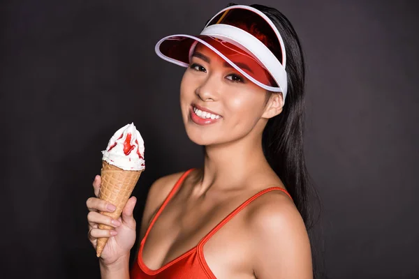 Woman in swimsuit and visor holding ice-cream — Stock Photo, Image