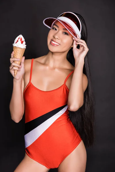 Woman in swimsuit and visor holding ice-cream — Stock Photo, Image