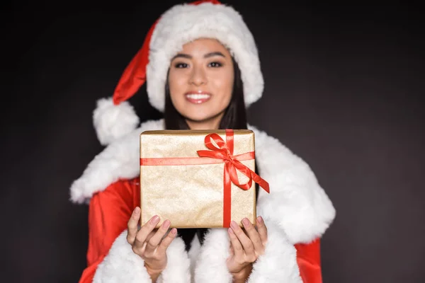 Mujer en traje de santa mostrando presente — Foto de Stock