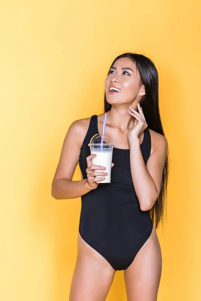 Женщина в купальнике держит молочный коктейль — стоковое фото