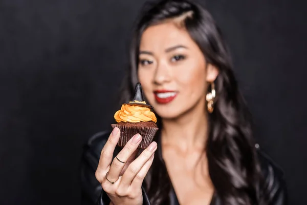 Frau hält Cupcake hoch — Stockfoto