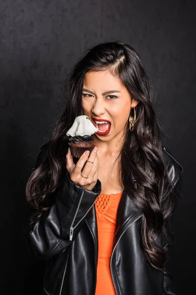 Frau isst Halloween-Cupcake — Stockfoto