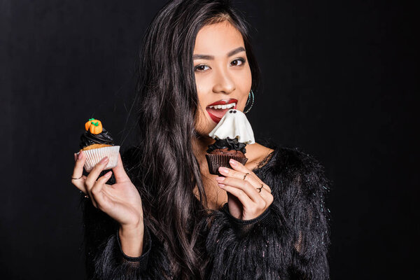 woman holding two cupcakes