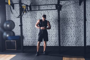 Akıllı telefon kullanan atletik adam