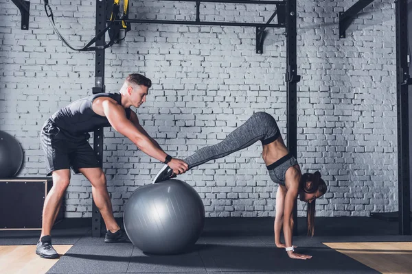Trainer helping woman work out — Stock Photo, Image