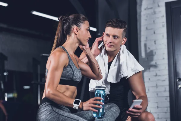 Couple listening music in gym — Stock Photo, Image