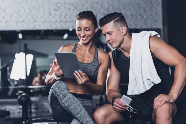 Pareja usando la tableta en el gimnasio — Foto de Stock