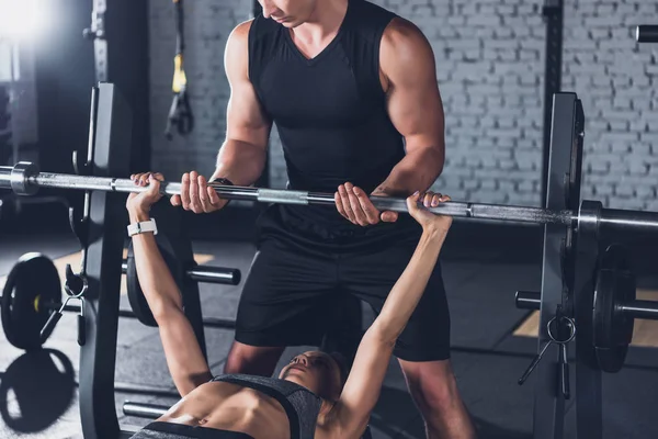 Trainer helping woman weightlifting — Stock Photo, Image