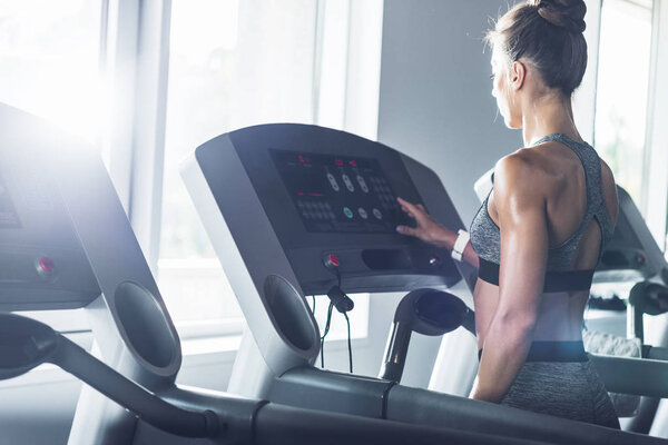 Женщина упражняется на беговой дорожке
