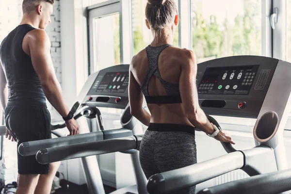 Pareja haciendo ejercicio en las cintas de correr — Foto de Stock