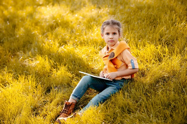 Enfant utilisant une tablette numérique dans le parc — Photo