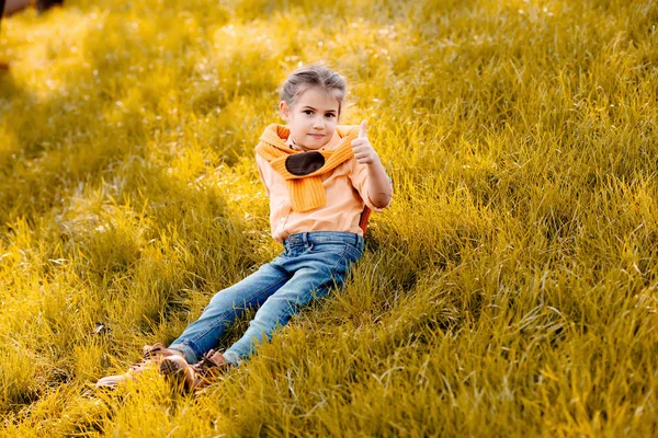 Child sitting in park — Free Stock Photo