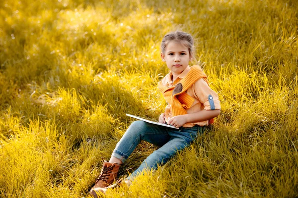 Child using digital tablet in park — Stock Photo, Image