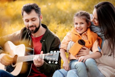Çimenli tepe üzerinde rahatlatıcı aile