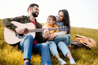 Çimenli tepe üzerinde rahatlatıcı aile