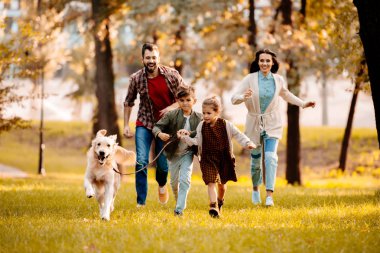 family running with dog in park clipart