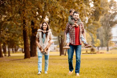 Parents giving children piggyback ride clipart