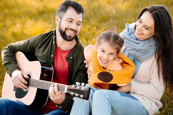 Man playing guitar with family — Stock Photo, Image