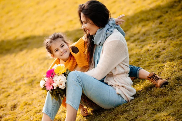 Daughter and mother sitting in park — Stock Photo, Image