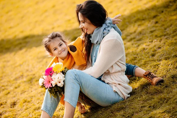 Dochter en moeder zitten in park — Stockfoto