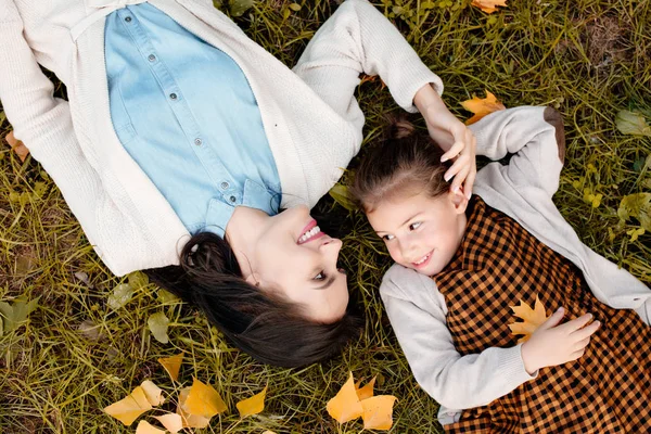 Moeder en dochter liggen op gras — Stockfoto