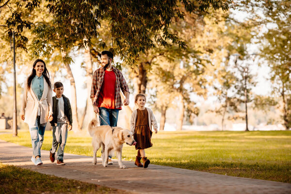 Family walking in park with dog