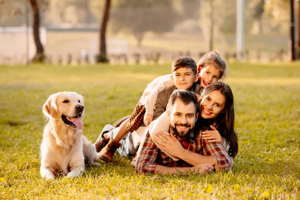 Familie liggen in stapel op gras — Stockfoto