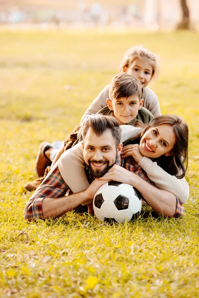 Familia acostada en la pila en la hierba — Foto de Stock