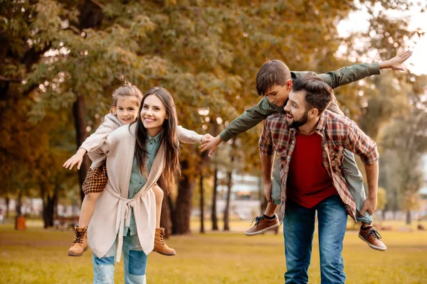 Parents giving children piggyback ride Stock Image