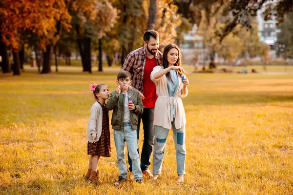 Family with children blowing bubbles — Stock Photo, Image