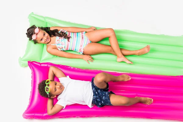 Kids in swimwear on swimming mattresses — Stock Photo, Image