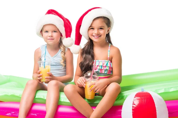 Crianças em chapéus de santa com suco de laranja — Fotografia de Stock