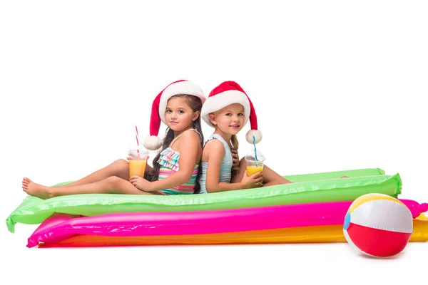 Kids in santa hats with orange juice — Stock Photo, Image