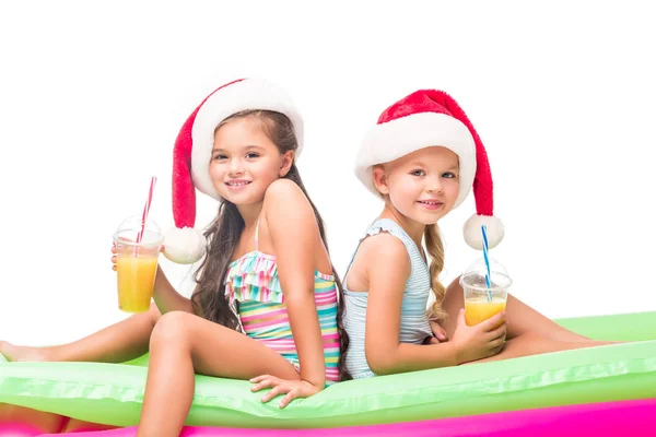 Crianças em chapéus de santa com suco de laranja — Fotografia de Stock