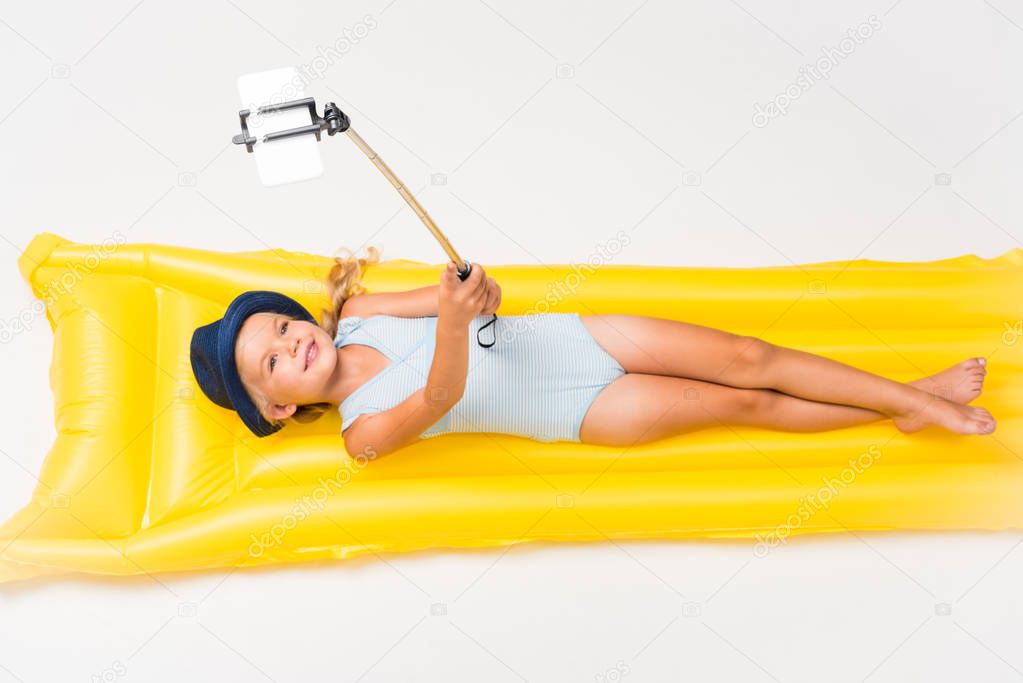 child taking selfie of swimming mattress